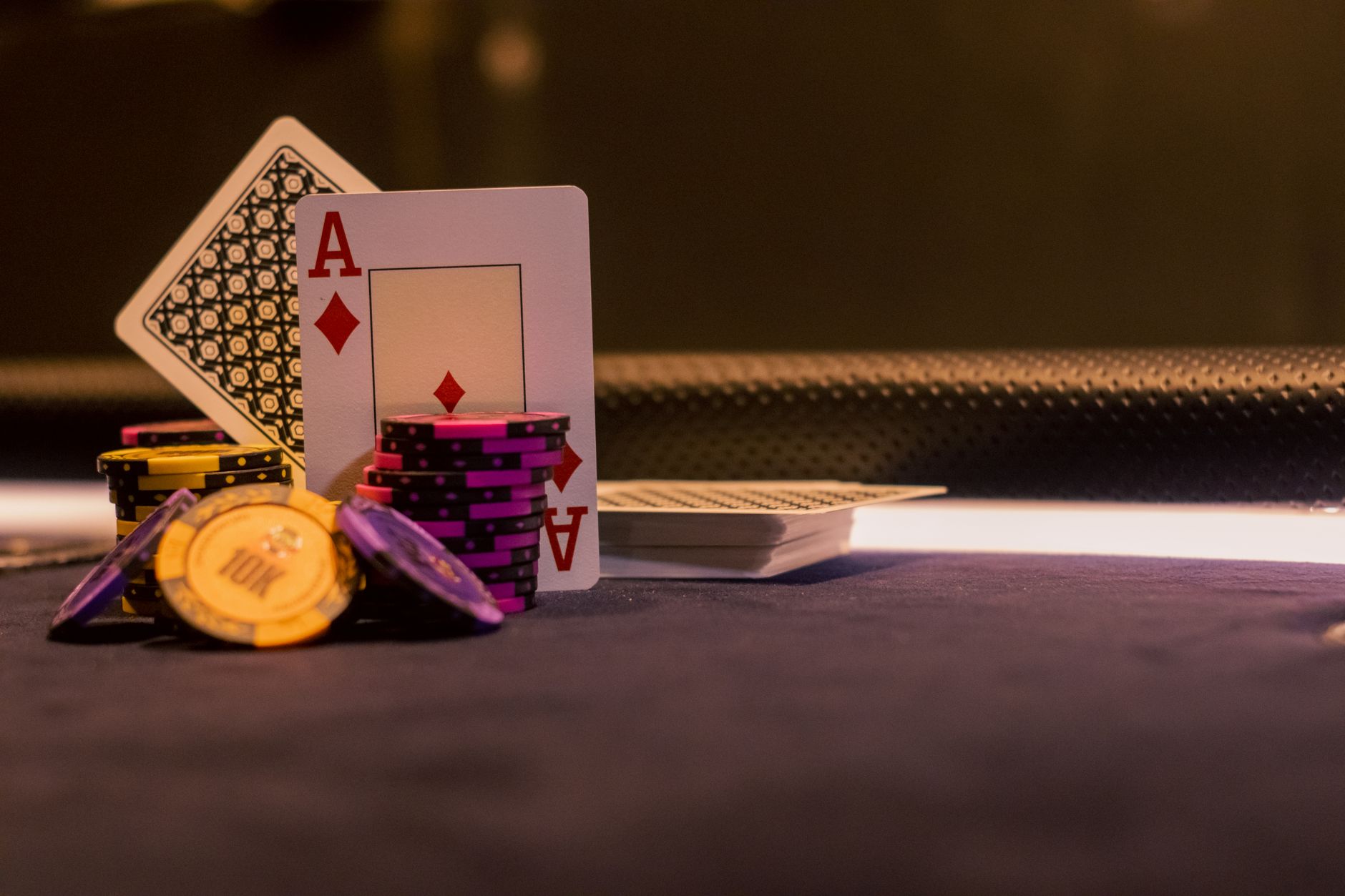 Gros plan de jetons de poker et de cartes à jouer sur une table de casino, mettant en évidence l'As de Carreau.